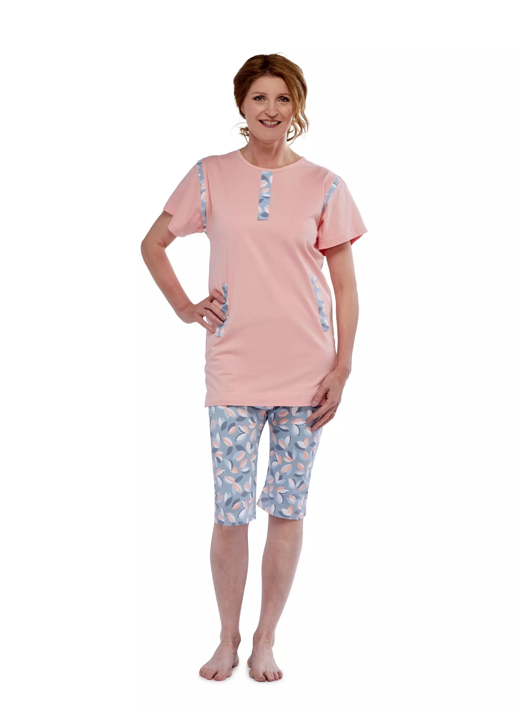 Pflegeoverall 1054 von 4Care für Damen, rosafarbenes Oberteil und geblümte Hose, kurzarm, mit Rückenreißverschluss, verhindert selbständiges Entkleiden, weiche Jerseyqualität, 100 % Baumwolle, waschbar bei 60 °C.