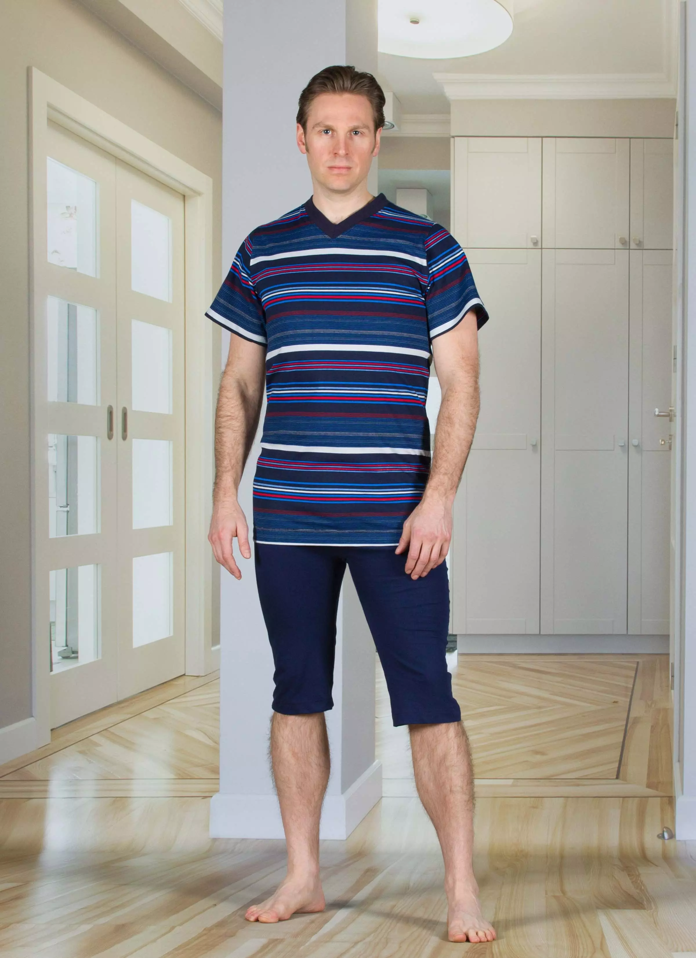 Marineblauer Pflegeoverall 1055 von 4Care für Herren, kurzarm und kurze Beine, aus weicher Baumwolle, mit praktischem Rückenreißverschluss für einfaches An- und Ausziehen, verhindert selbständiges Entkleiden, waschbar bei 60 °C.